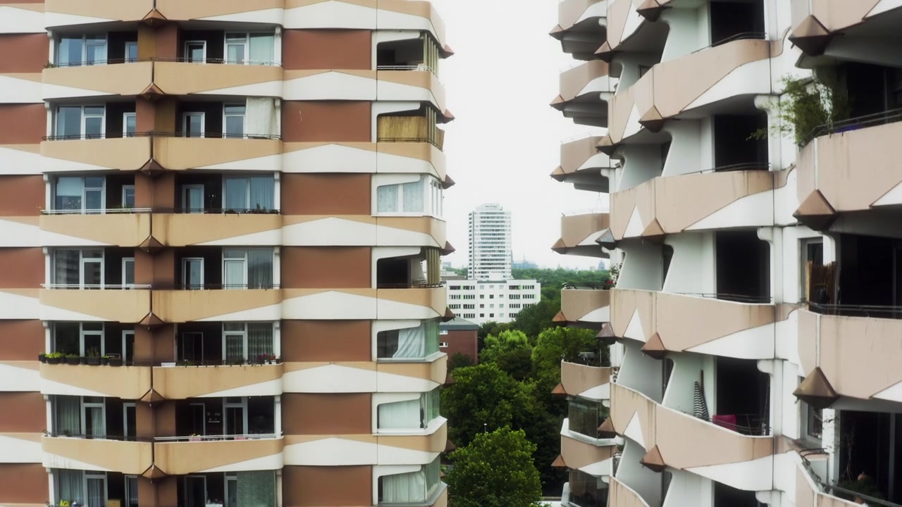 Balcones geométricos en apartamentos de Colonia mientras el dron asciende para revelar una torre.