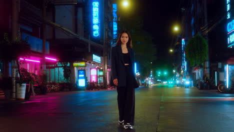 stylish woman posing on a vibrant neon-lit city street at night