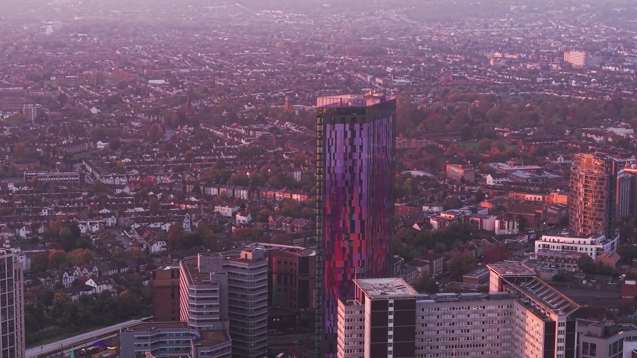 Vista aérea em direção aos arranha-céus Croydon Saffron e à paisagem urbana do centro iluminada pelo sol ao entardecer.