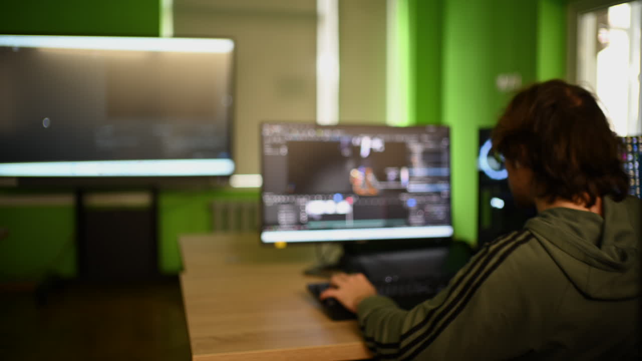 Homem trabalhando em software de edição de vídeo no computador em um espaço de trabalho moderno.