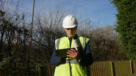 a mature professional architect with a tablet inspecting a construction building site