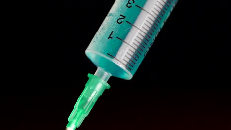 close-up of a syringe with blue liquid