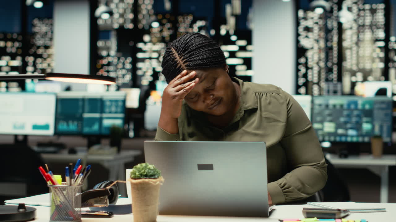 Troubled overworked woman sighing after realizing the late hour