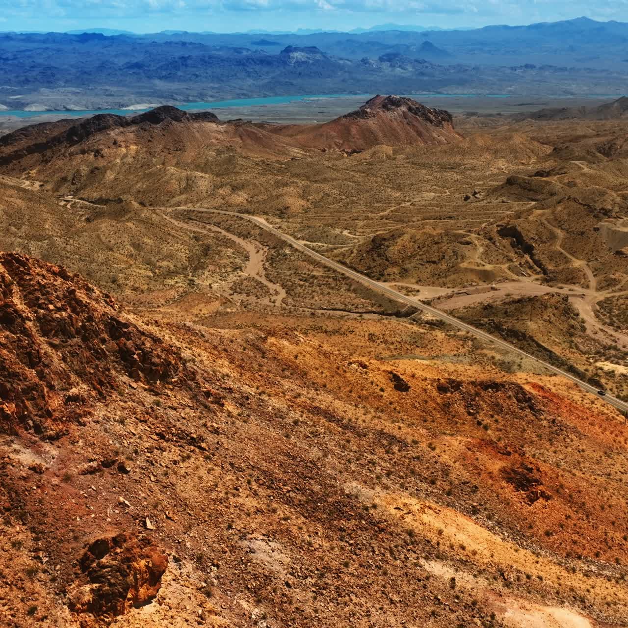Voo sobre o topo de uma montanha seca e sem vegetação. Paisagem do deserto de Mojave em um dia ensolarado