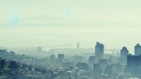 Animation-of-bitcoin-icons-floating-over-aerial-view-of-cityscape-against-cloudy-sky