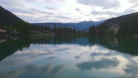 Toma-Frontal-De-Un-Dron-Del-Gran-Lago-Dobbiaco-Y-Su-Reflejo-En-Toblacher-See,-Tirol-Del-Sur,-Italia