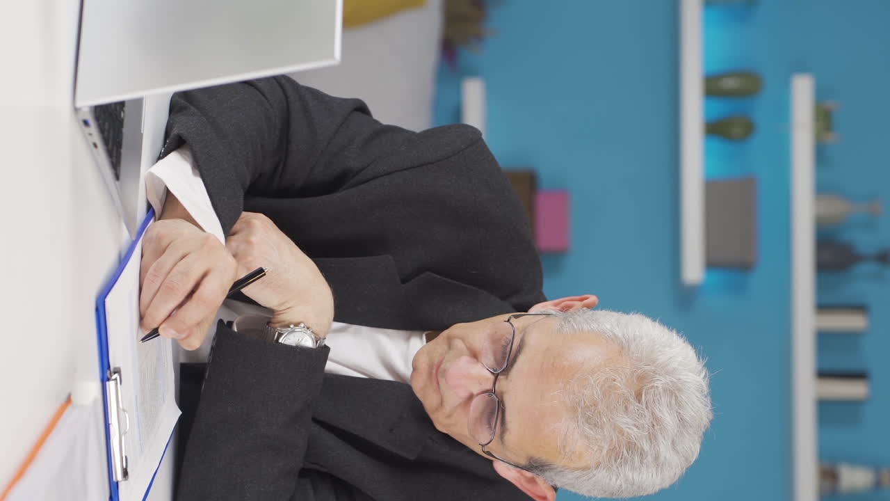 홈 오피스 직원 남자가 연구를 하는 수직 비디오.