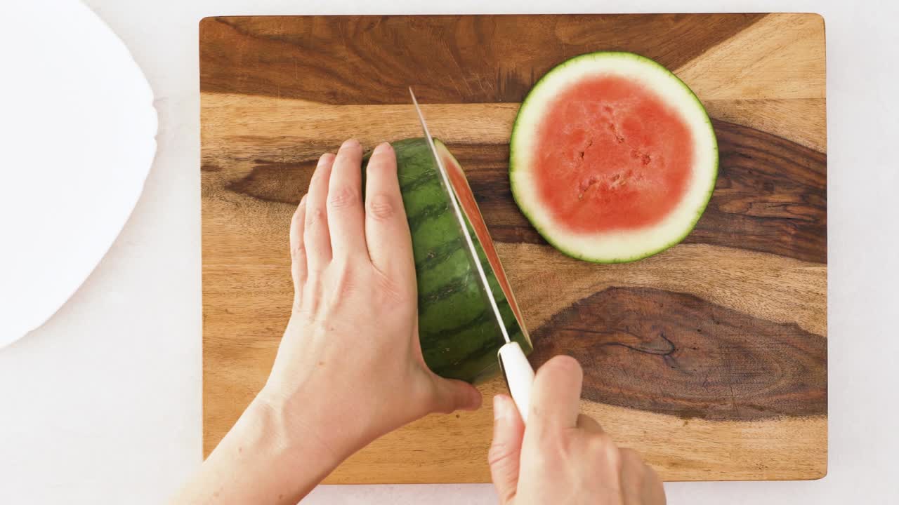 나무 의 절단판 에 수박 을 잘라내는 여자