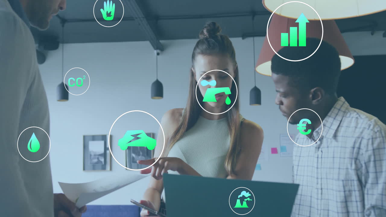 Animation of ecology icons over diverse colleagues using laptop and discussing work in office