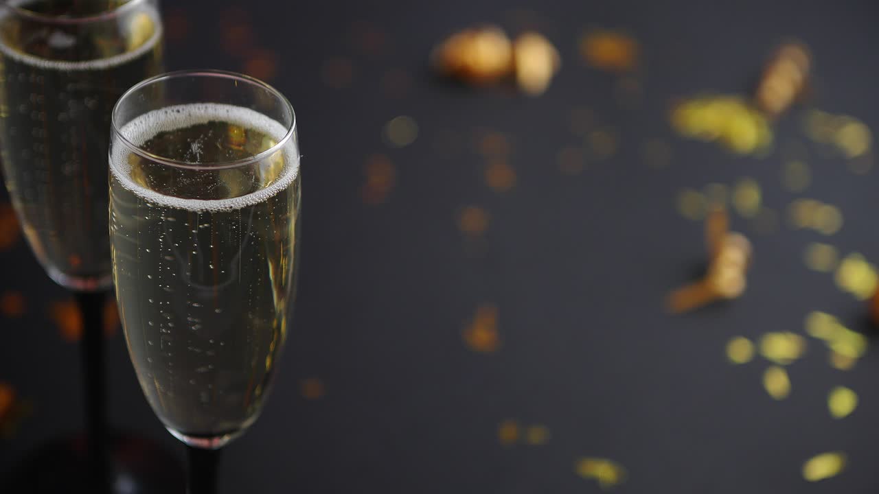 Due calici pieni di spumante champagne con decorazioni dorate.