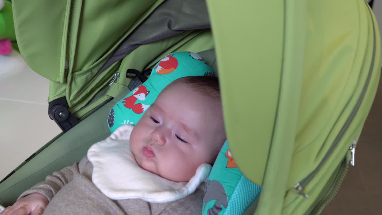 Adorable baby girl lying in stroller when Mom shaking it to calm her down