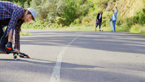 front view of cool young caucasian man doing skateboard trick on downhill at countryside road 4k