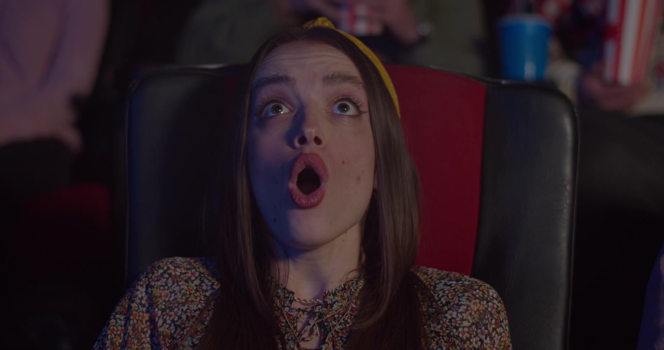 Młoda kobieta oglądająca film w kinie