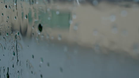 gota de lluvia en cámara lenta sobre una ventana de cristal.