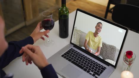 Mittelteil-Einer-Afroamerikanischen-Frau,-Die-Wein-Trinkt,-Während-Sie-Zu-Hause-Einen-Videoanruf-Auf-Dem-Laptop-Führt