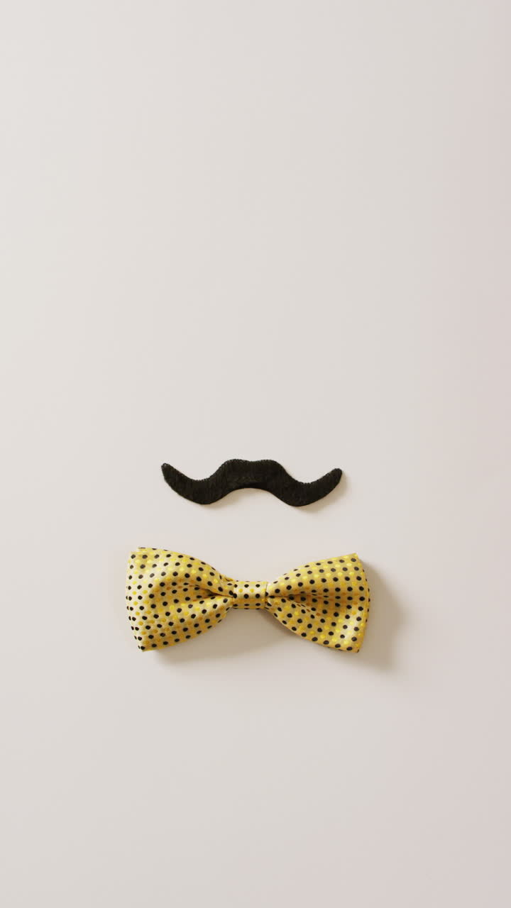 video vertical de bigote falso negro y corbata amarilla sobre fondo blanco con espacio para copiar