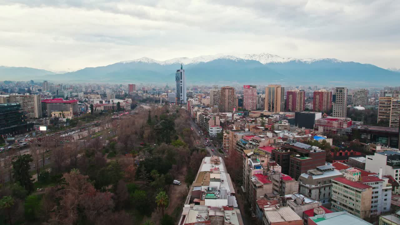 Drone establishing shot over Lastarria neighborhood and Forestal park on a cloudy morning, Telefonica tower in Santiago Chile