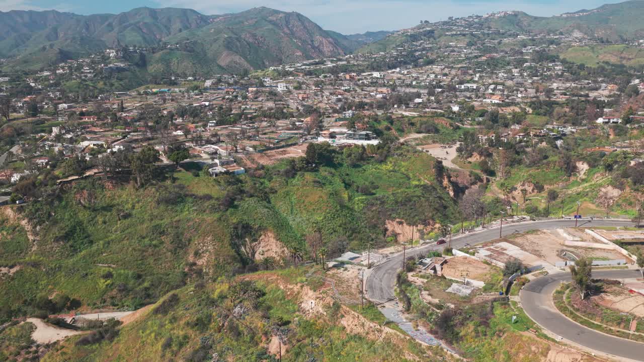 Ripresa aerea bassa con effetto pullback inverso di proprietà incendiate durante la primavera a Pacific Palisades, California. 4K.