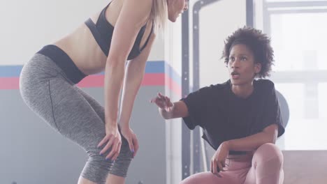 video de una entrenadora de fitness y una mujer hablando después de hacer ejercicio en un gimnasio