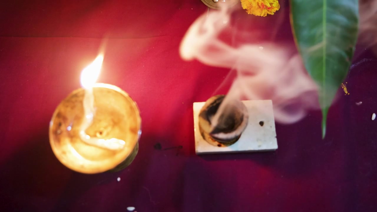 Lampada a olio accesa con fumo di incenso durante una cerimonia di culto religioso indù.