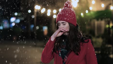 vista de cerca de una mujer caucásica con mascarilla médica tosiendo en la calle mientras nieva en navidad