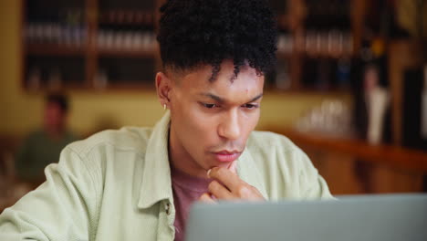 man thinking in front of a laptop
