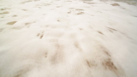 ocean wave on sandy beach.