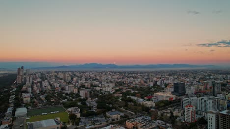 aerial revealing panoramic over santo domingo and the moon on the horizon at sunset