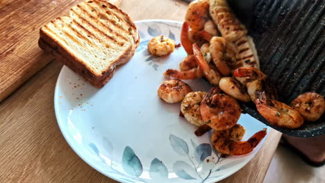 delicious toast topped with cooked shrimps and melted cheese being added on a plate.