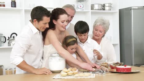 parents, grandparents and children baking in the kitchen