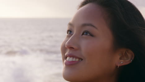 close up portrait beautiful asian woman enjoying freedom exploring wanderlust feeling relaxed on seaside contemplating spirituality at sunset with wind blowing hair