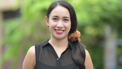 young beautiful asian businesswoman smiling in the streets outdoors