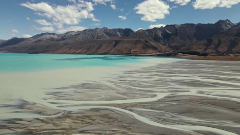 braided tasman river delta as it flows into turquoise lake pukaki