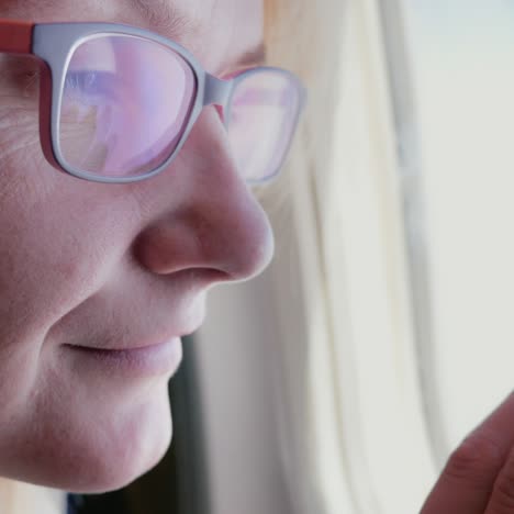 una mujer con gafas mira la ventana del avión