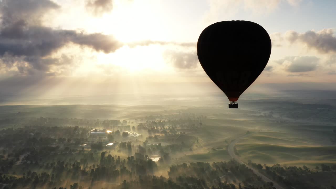 el amanecer del globo de aire caliente sobre un valle de niebla