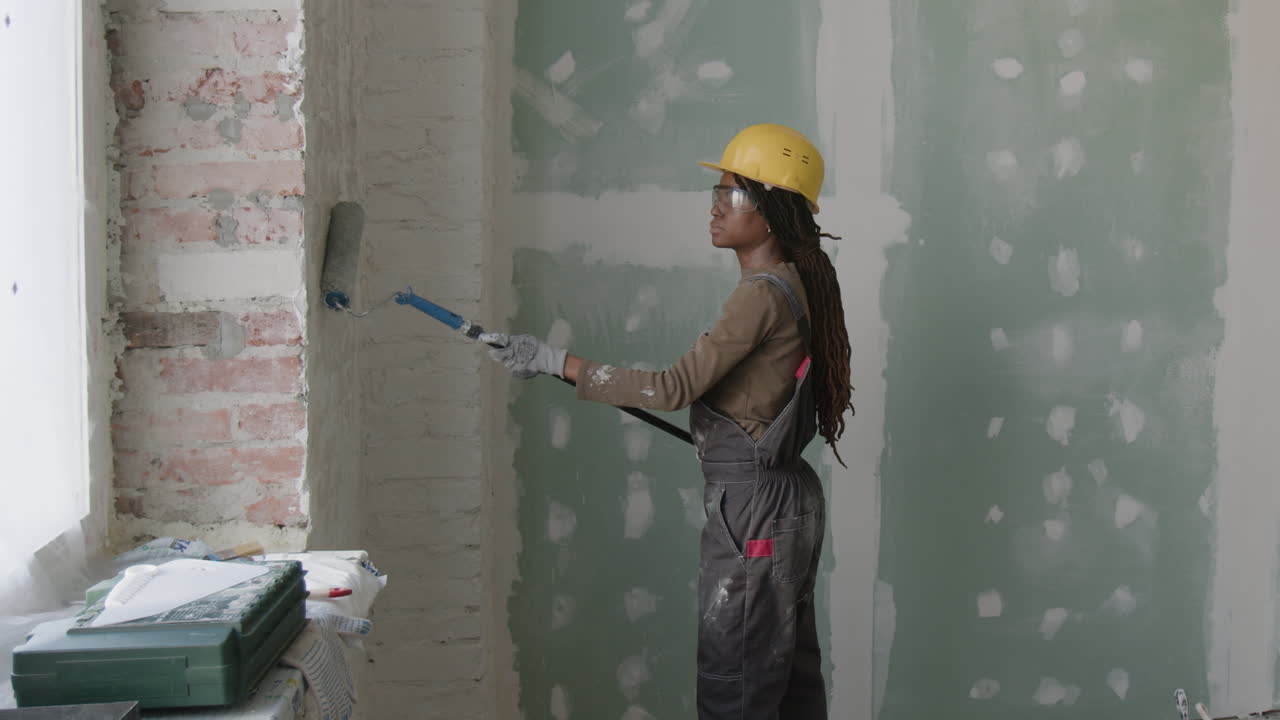 Una mujer pintando una pared.