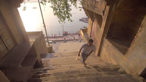 man climbing steps away from the river ganges