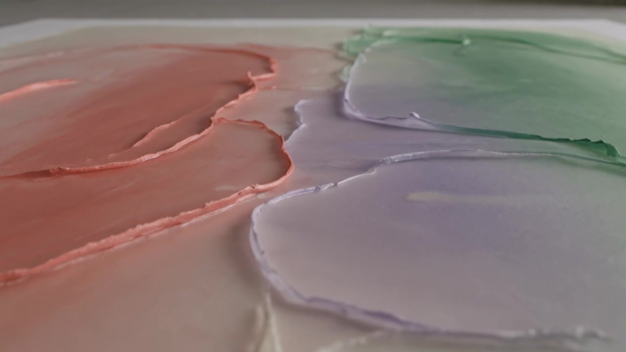 Kamera med skiftende fokus avslører en svak utflating på et studiopanel, med pastellstrøk.