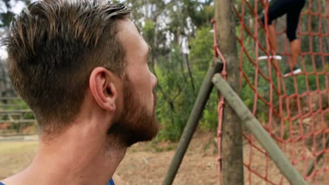 retrato de un entrenador masculino de pie en el parque durante una carrera de obstáculos