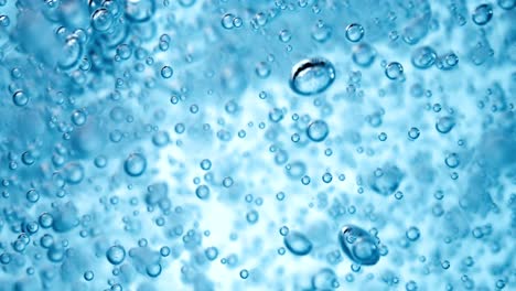 muchas burbujas de agua en agua azul de cerca, onda de agua abstracta con burbujas en cámara lenta.