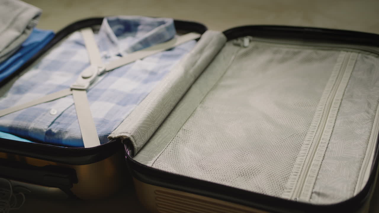 여자는 여행 가방에 옷과 보호 마스크를 넣습니다.