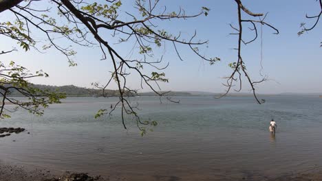 lake view of goa through tree branches. local guys from goa standing close to the lake