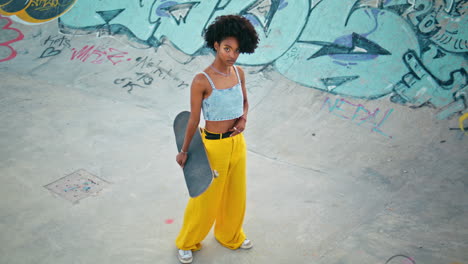 model posing skateboard standing skate park. girl holding longboard