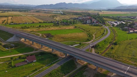 Timelapse-of-highway-over-road-near-Rasnov,-scenic-fields-and-mountains