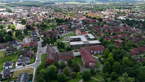 picturesque american neighborhood with green trees on streets in summer. aerial wide shot. historic hospitals building and red brick roofs of homes in united states. quiet scene