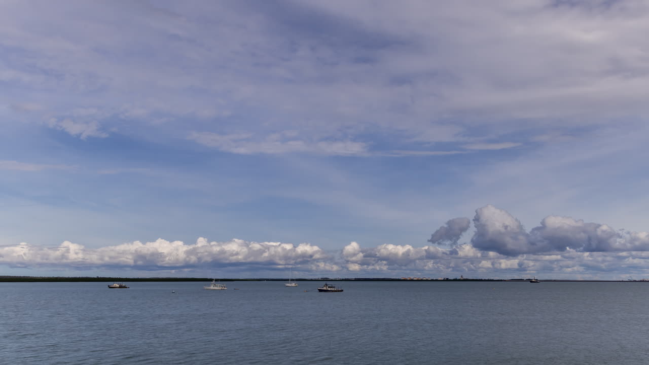 우기 동안 보트가 정박한 다윈 항구에 폭풍 구름이 쌓이는 시간 경과