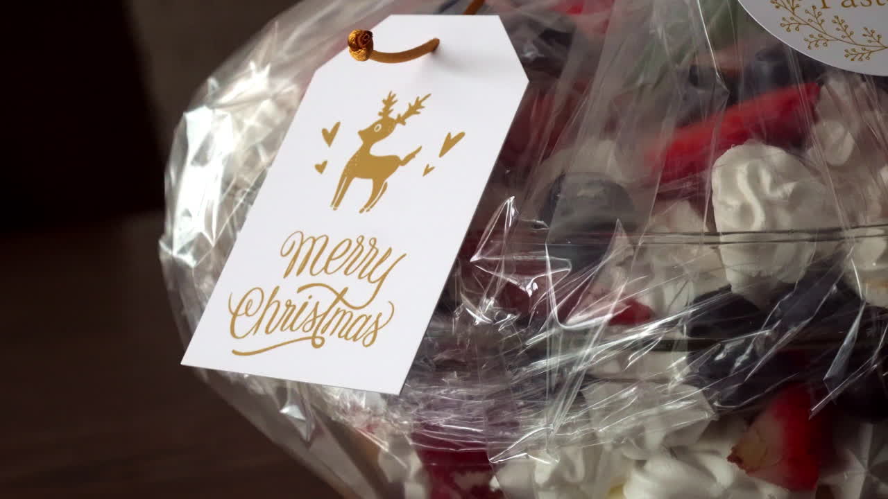 크리스마스 카드 태그가 있는 포장된 디저트 선물의 근접 촬영 궤도