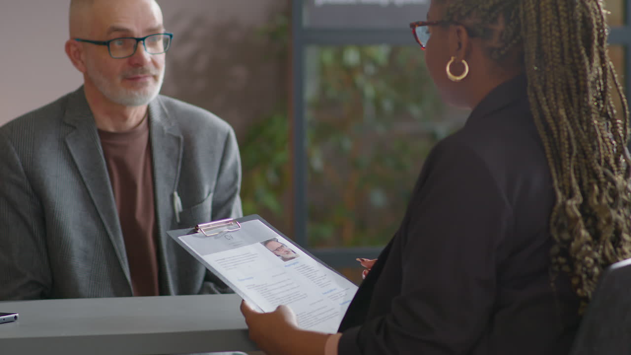 Senior Businessman Having Job Interview with Female HR Manager