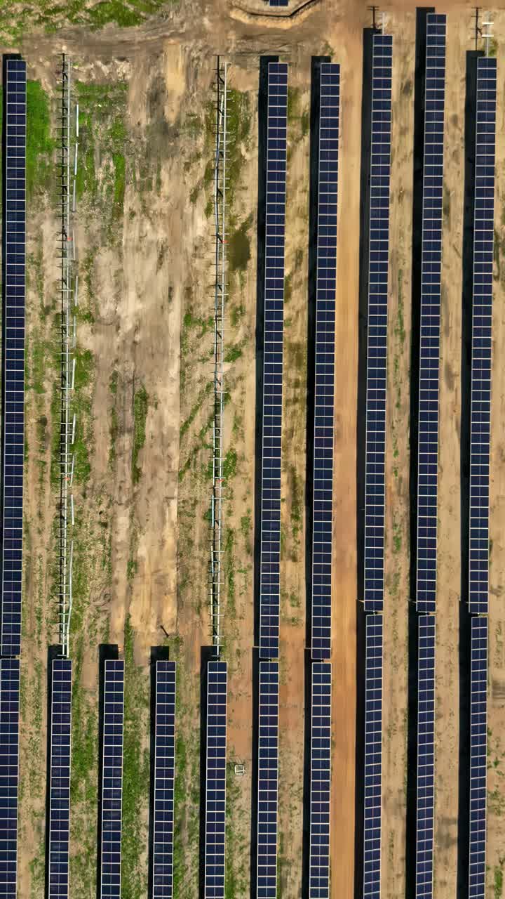 Vertical video of partially constructed solar farm featuring panel arrays