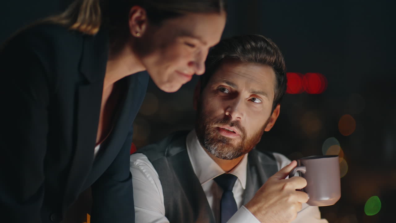 Gente de negocios trabajando de noche en primer plano. Gerentes corporativos nocturnos discuten un proyecto.